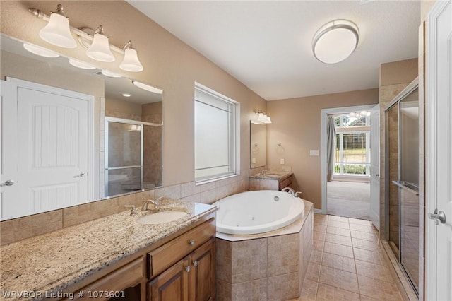 bathroom featuring plus walk in shower, vanity, and tile patterned floors