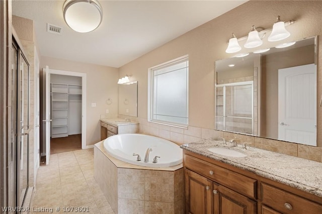 bathroom with tile patterned floors, vanity, and shower with separate bathtub