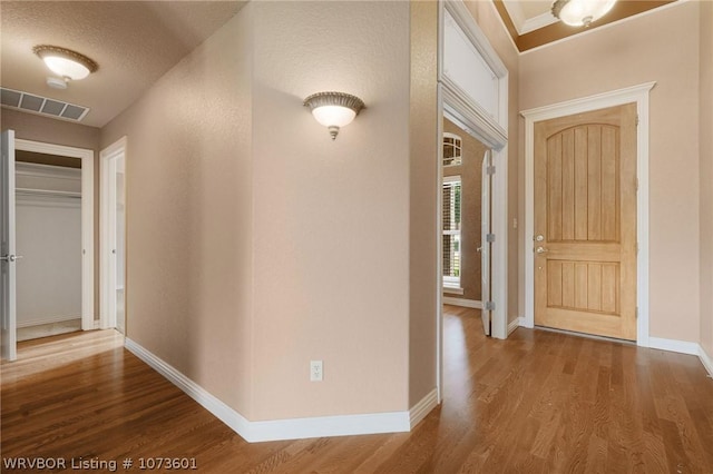 hall with hardwood / wood-style flooring and a textured ceiling