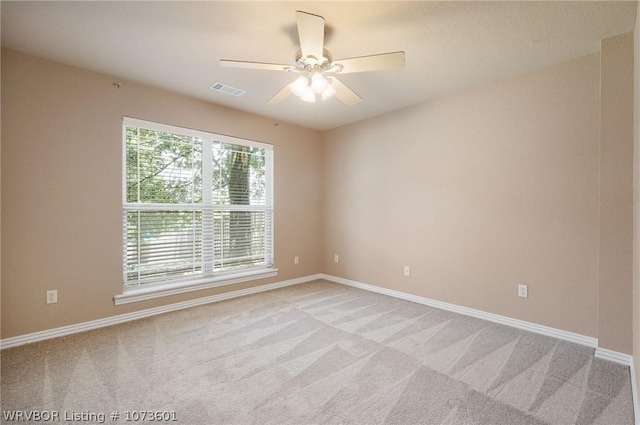 carpeted spare room with ceiling fan