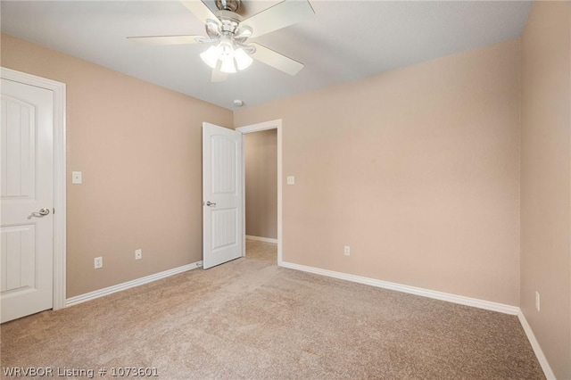 carpeted spare room with ceiling fan