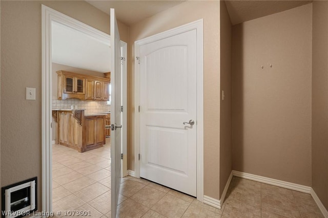 corridor with heating unit and light tile patterned floors