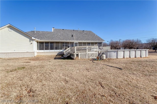 back of property featuring a yard and a sunroom