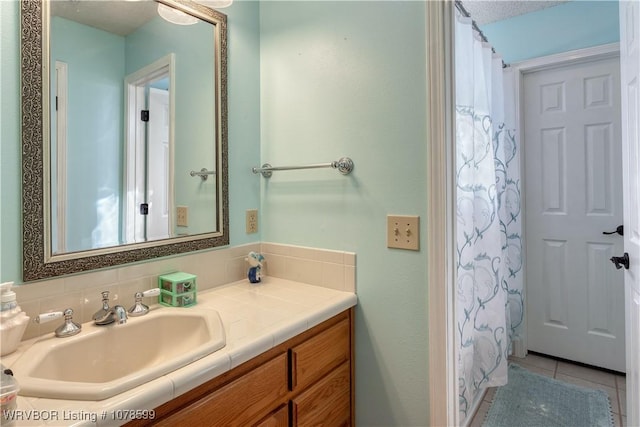 bathroom featuring vanity, backsplash, tile patterned floors, and walk in shower