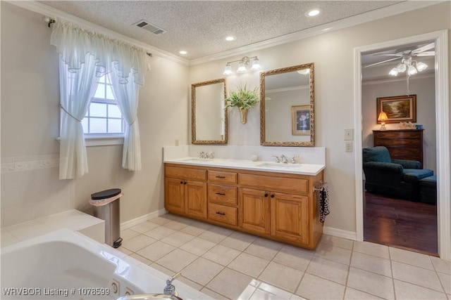 bathroom featuring vanity, ornamental molding, tile patterned floors, and a textured ceiling