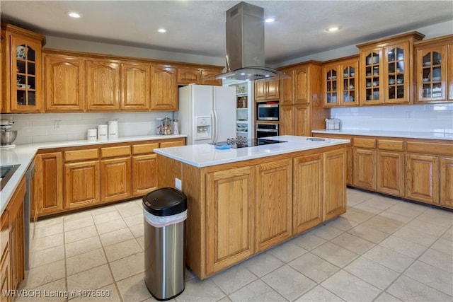 kitchen with light tile patterned flooring, island range hood, a center island, appliances with stainless steel finishes, and decorative backsplash