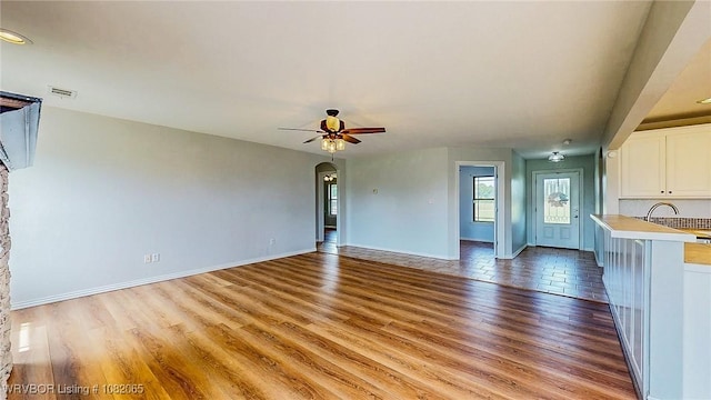 6562 Broadleaf Dr, Alma, AR 72921 - unfurnished living room featuring light wood-style flooring, a ceiling fan, and arched walkways