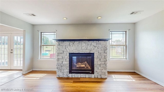 6562 Broadleaf Dr, Alma, AR 72921 - unfurnished living room with wood finished floors, healthy amount of natural light, a fireplace, french doors, and recessed lighting