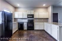 kitchen with black appliances, white cabinets, light countertops, and a peninsula