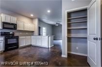 kitchen featuring black appliances, white cabinets, recessed lighting, and a peninsula