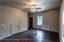 empty room with baseboards and ceiling fan