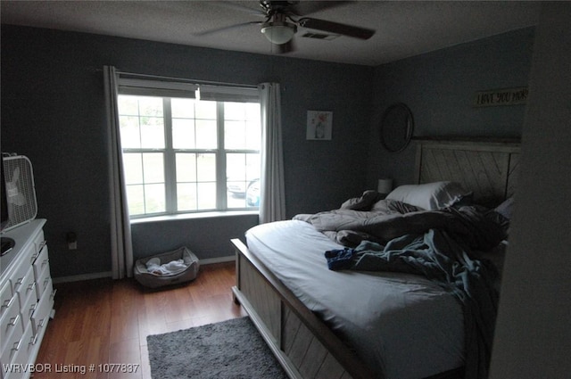 bedroom with dark hardwood / wood-style flooring and ceiling fan