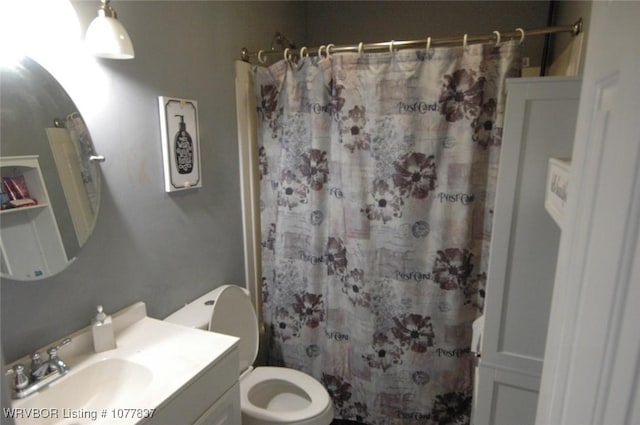 bathroom with vanity, curtained shower, and toilet