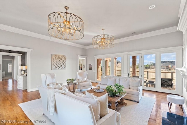 living area featuring crown molding, french doors, a chandelier, wood finished floors, and baseboards