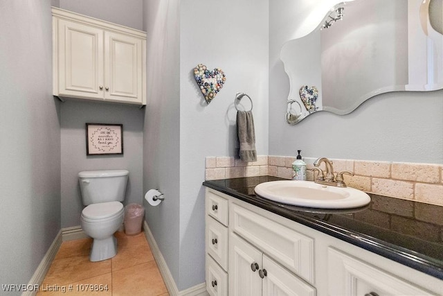 bathroom featuring baseboards, toilet, tile patterned flooring, and vanity