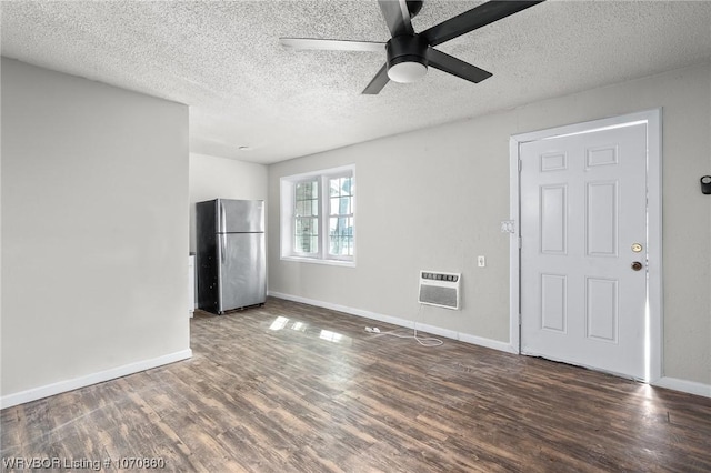 interior space featuring ceiling fan, dark hardwood / wood-style floors, an AC wall unit, and a textured ceiling