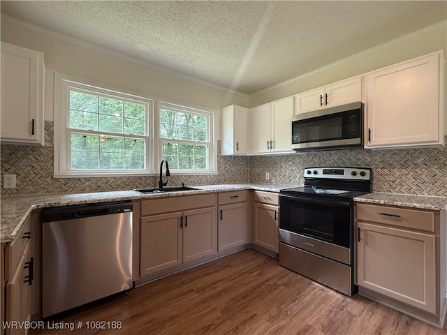 1505 E Main St, Lavaca, AR 72941 - kitchen with stainless steel appliances, dark wood finished floors, a textured ceiling, tasteful backsplash, and crown molding