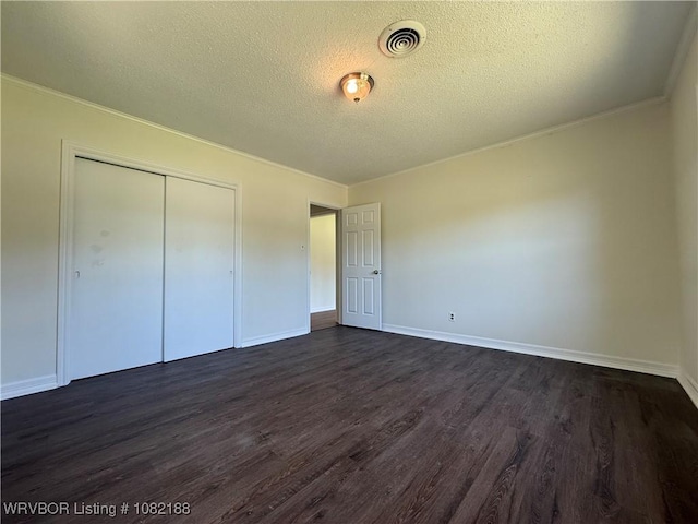 1505 E Main St, Lavaca, AR 72941 - unfurnished bedroom featuring a textured ceiling, dark wood finished floors, a closet, and ornamental molding