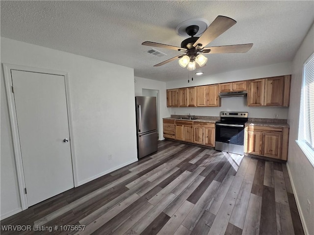 kitchen featuring dark wood-type flooring, sink, ceiling fan, a textured ceiling, and appliances with stainless steel finishes