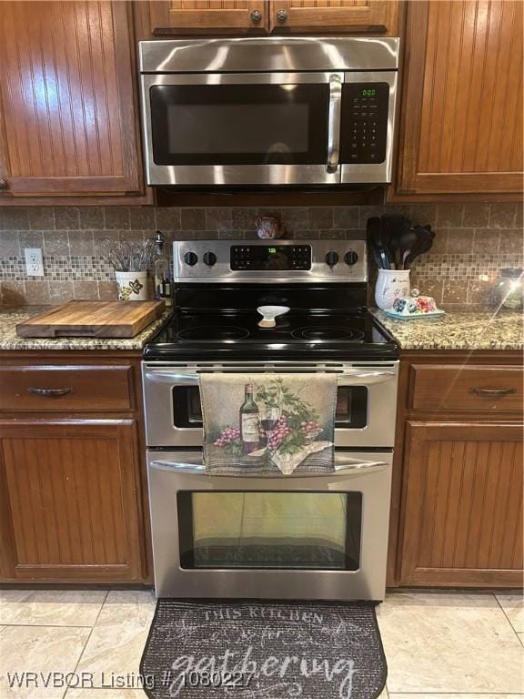 304 Caseys Ct, Lavaca, AR 72941 - kitchen featuring brown cabinets, backsplash, and appliances with stainless steel finishes