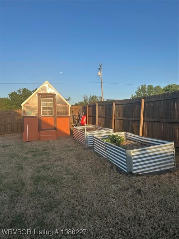 304 Caseys Ct, Lavaca, AR 72941 - view of yard featuring a fenced backyard, a vegetable garden, an outdoor structure, and a greenhouse