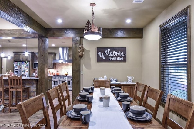 dining space featuring hardwood / wood-style flooring and beam ceiling