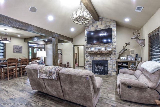 living room featuring vaulted ceiling with beams, wood-type flooring, a fireplace, and a chandelier