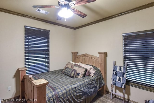 bedroom featuring ceiling fan, light hardwood / wood-style flooring, and ornamental molding