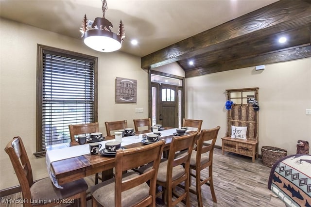 dining room with plenty of natural light, wood-type flooring, and vaulted ceiling