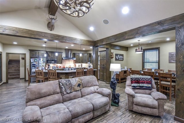 living room featuring vaulted ceiling with beams, hardwood / wood-style flooring, and an inviting chandelier