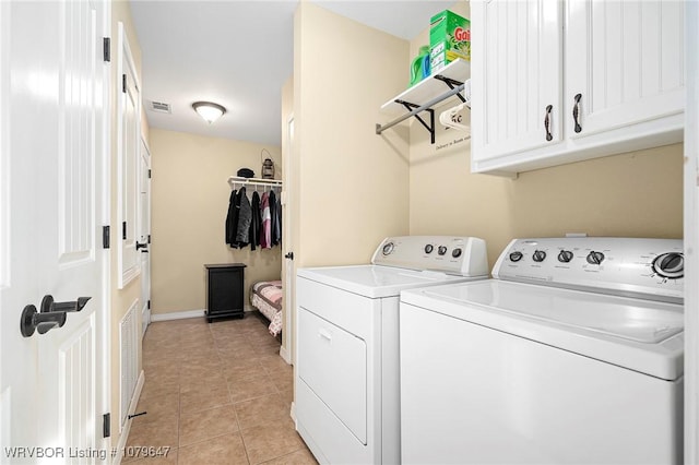 washroom featuring visible vents, baseboards, light tile patterned flooring, cabinet space, and washing machine and dryer