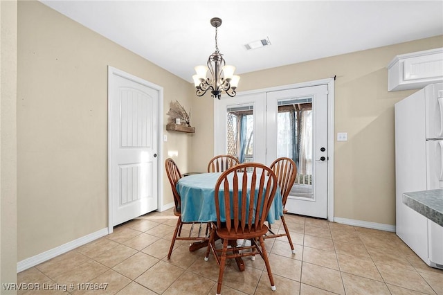 dining space featuring a notable chandelier, baseboards, visible vents, and light tile patterned flooring