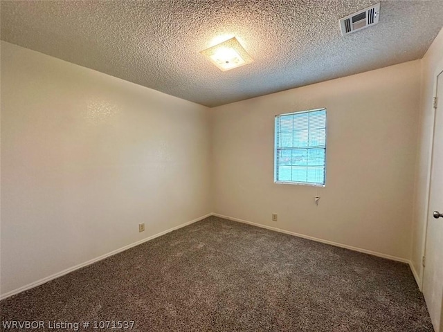 carpeted empty room with a textured ceiling