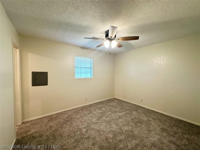 carpeted spare room with electric panel, ceiling fan, and a textured ceiling