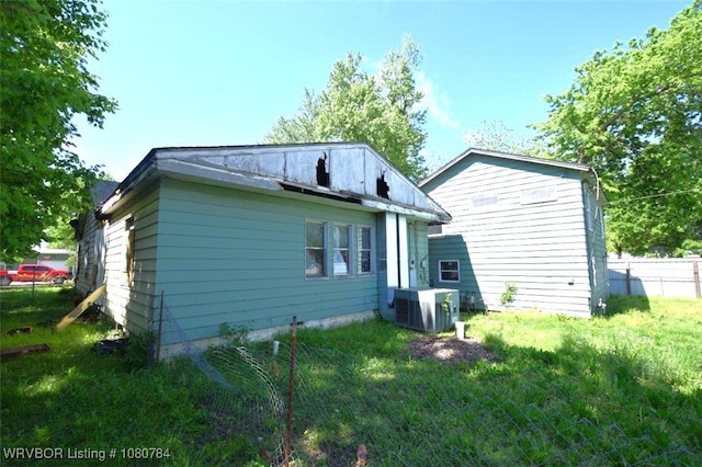 back of house with fence and central AC