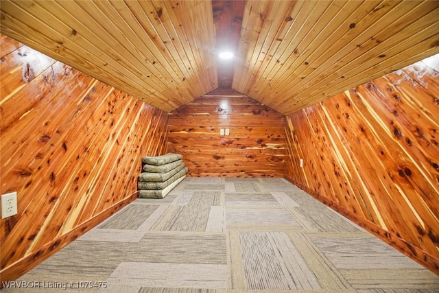 additional living space with wooden walls, a sauna, wooden ceiling, and vaulted ceiling