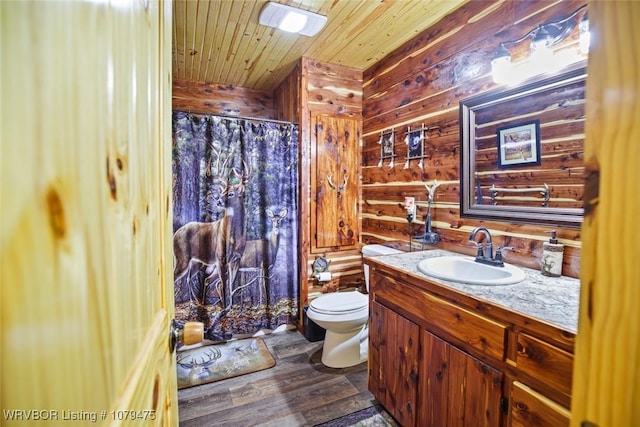 bathroom featuring toilet, wood finished floors, wood walls, wooden ceiling, and vanity