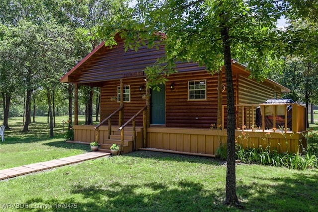 cabin with faux log siding and a front yard