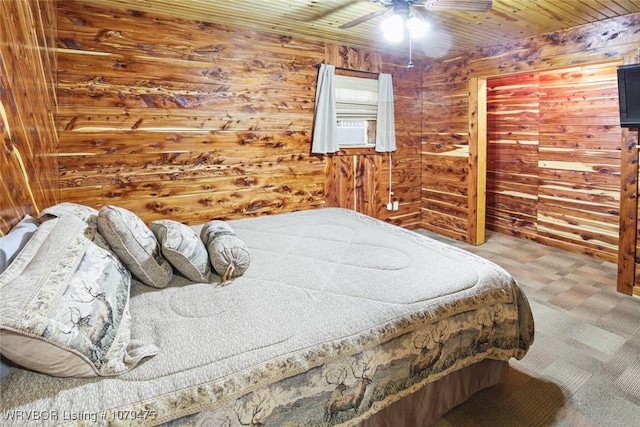 carpeted bedroom with wood walls, wood ceiling, and a ceiling fan