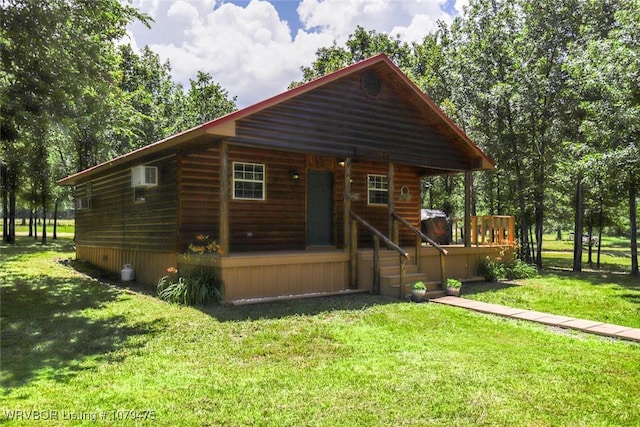 view of front of home with covered porch, a front lawn, and a wall mounted AC