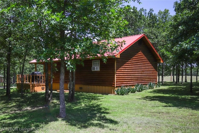 view of side of home with metal roof, a lawn, and a deck