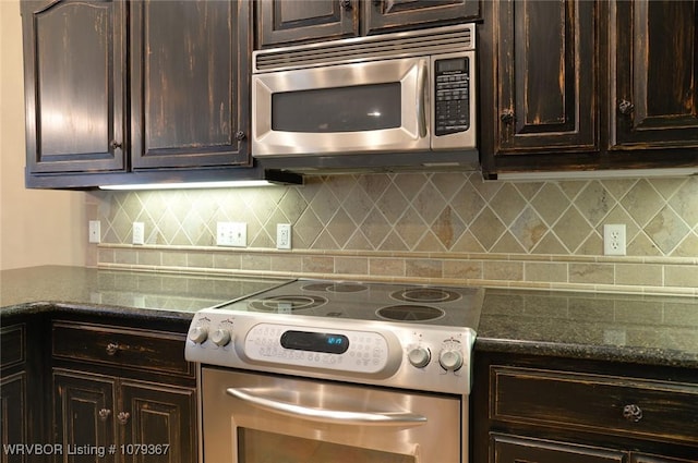 kitchen with dark brown cabinetry, tasteful backsplash, appliances with stainless steel finishes, and dark stone counters