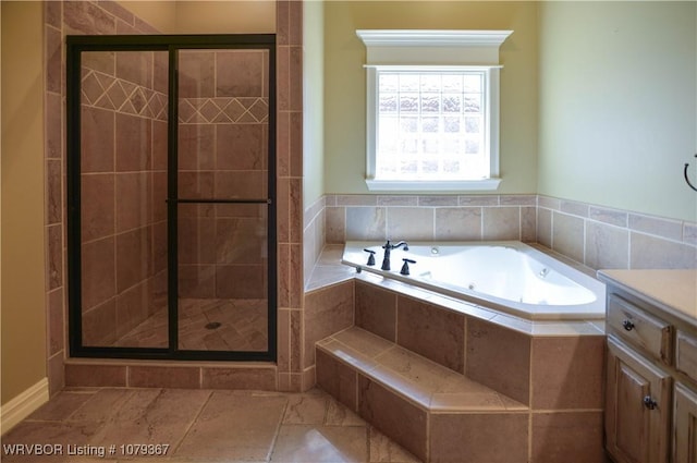 bathroom with a jetted tub, a stall shower, and vanity