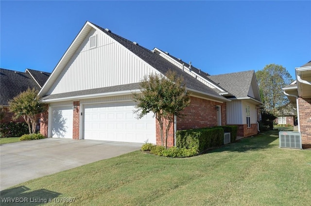 view of side of property with driveway, a garage, a lawn, cooling unit, and brick siding