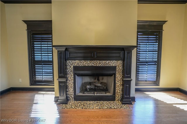 details with a fireplace, baseboards, and wood finished floors