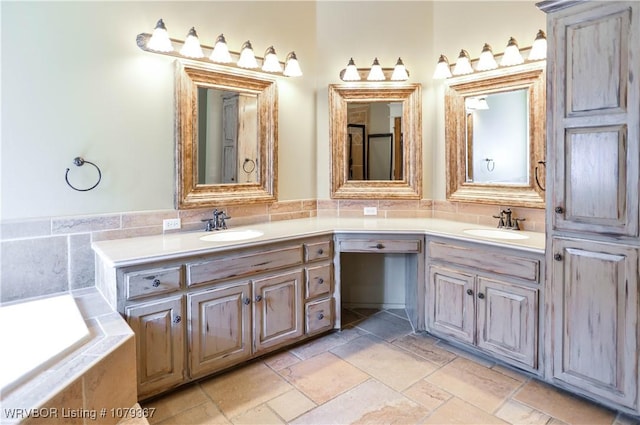 bathroom featuring double vanity, stone tile flooring, and a sink