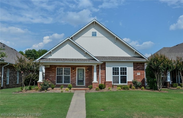 craftsman inspired home with roof with shingles, a front lawn, and brick siding