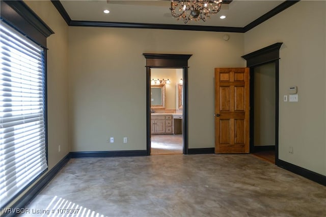 spare room with a chandelier, baseboards, concrete flooring, and crown molding