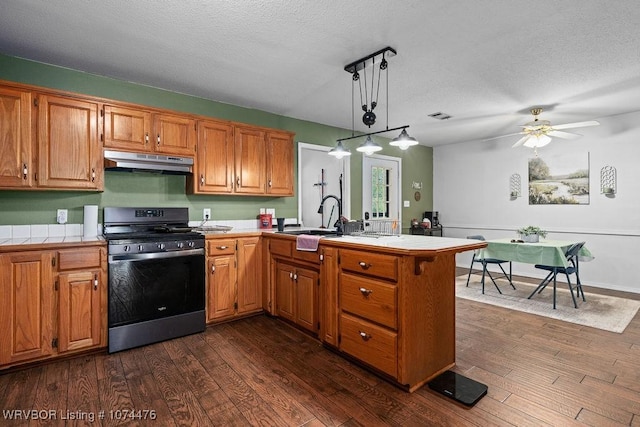 451 Hill St, Booneville, AR 72927 - kitchen featuring a sink, under cabinet range hood, stainless steel range with gas cooktop, a peninsula, and tile countertops