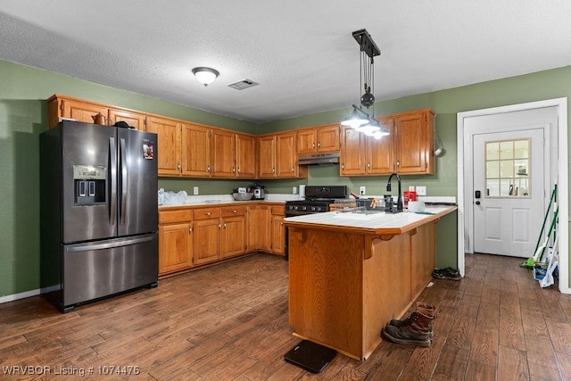 451 Hill St, Booneville, AR 72927 - kitchen with under cabinet range hood, stainless steel fridge, visible vents, a peninsula, and dark wood finished floors